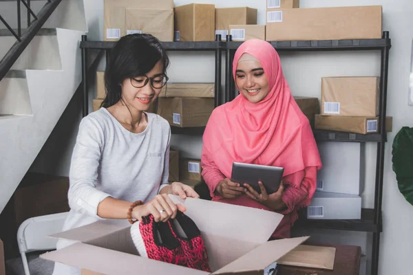 Penjual produk fashion sedang mengemas pesanan pelanggan