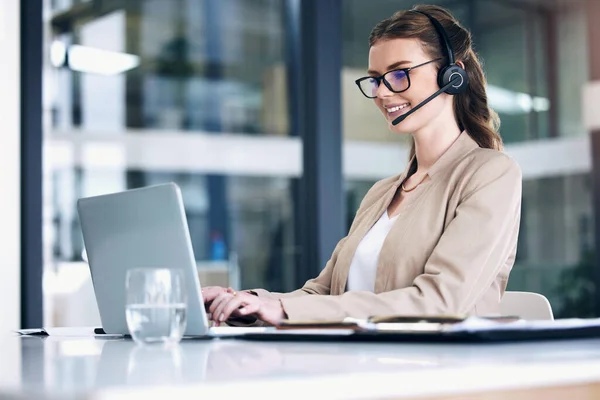 Seorang customer service sedang bekerja menggunakan laptop