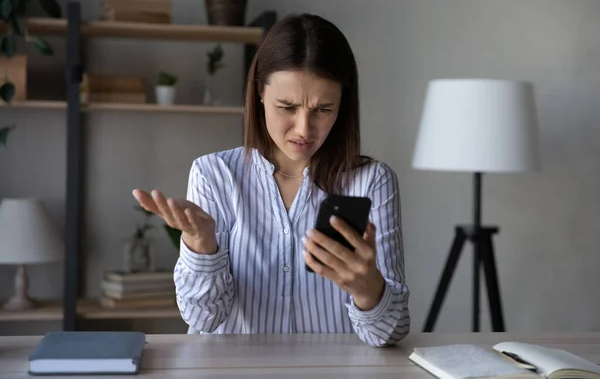 Seorang perempuan frustasi saat menggunakan ponselnya