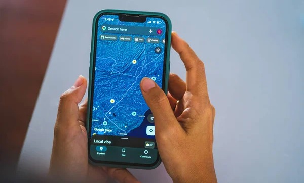 Seseorang sedang membaca peta satelit di HP