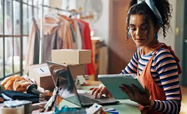 Pemilik online shop sedang menggunakan laptop untuk bekerja
