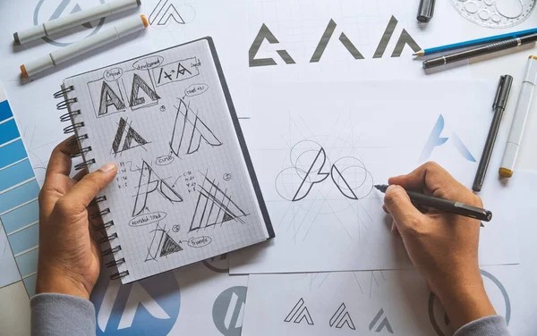 Desainer grafis sedang membuat sketsa logo