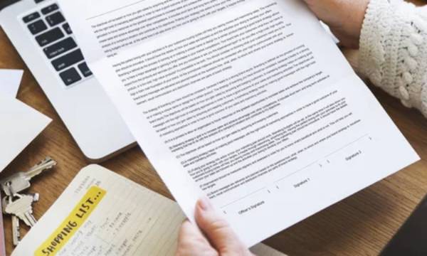 Seseorang sedang membaca surat resmi dari perusahaan