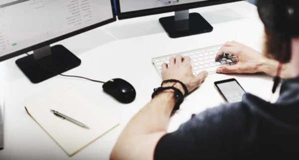 Staff CS bekerja menggunakan dua monitor