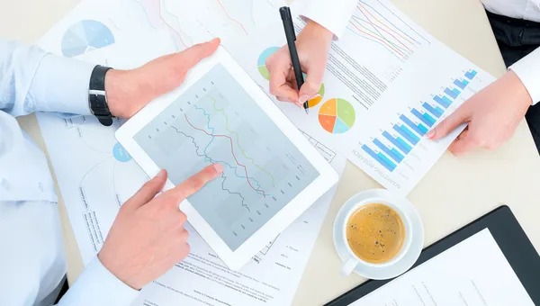Tim marketing sedang menganalisis grafik dan chart