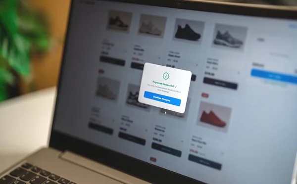 Laptop menampilkan notifikasi pembayaran berhasil di toko online