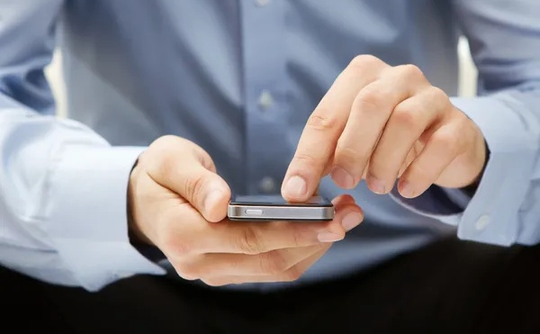 Pekerja sedang menggunakan ponsel untuk mengirim pesan