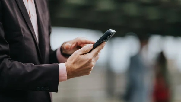 Seorang pebisnis sedang membaca pesan di HP