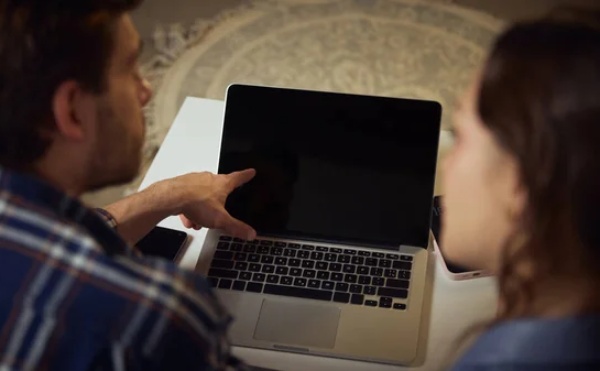 Seseorang menunjuk layar laptop untuk menjelaskan sesuatu