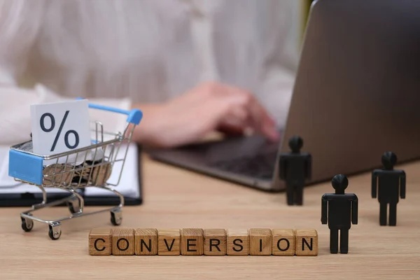Staf sedang bekerja dengan dekorasi balok bertuliskan conversion di atas meja