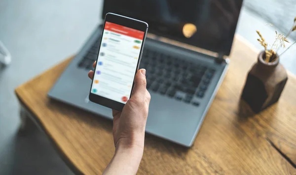 Seseorang sedang mengecek inbox email di HP