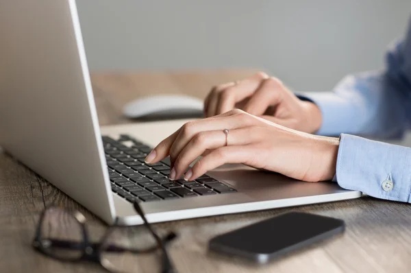 Staff marketing sedang mengetik email di laptop